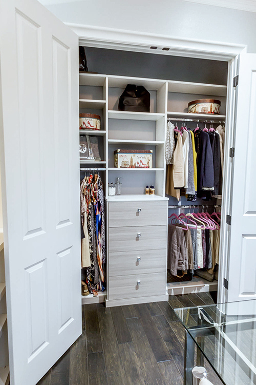 Built-in closet organizer with drawers, shelves, and hanging space