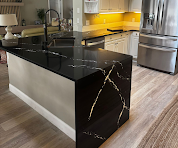 Black marble waterfall kitchen island with yellow backsplash