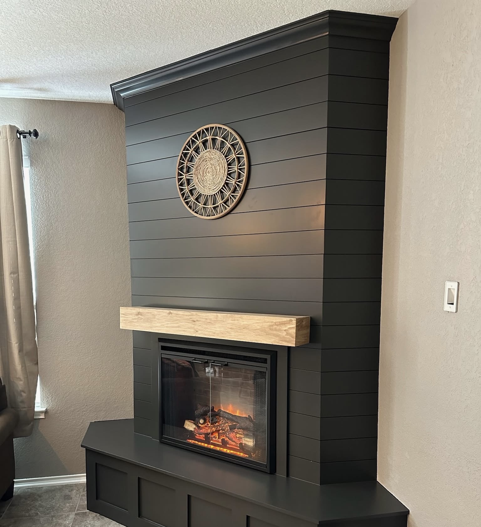 Shiplap fireplace feature with built-in niche shelving and wood mantel