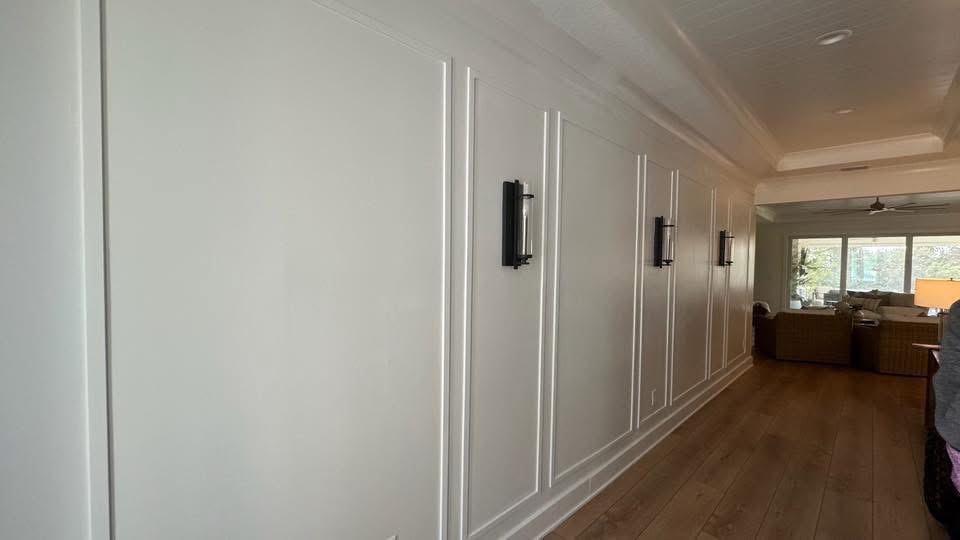 White wainscoted hallway with wall sconces