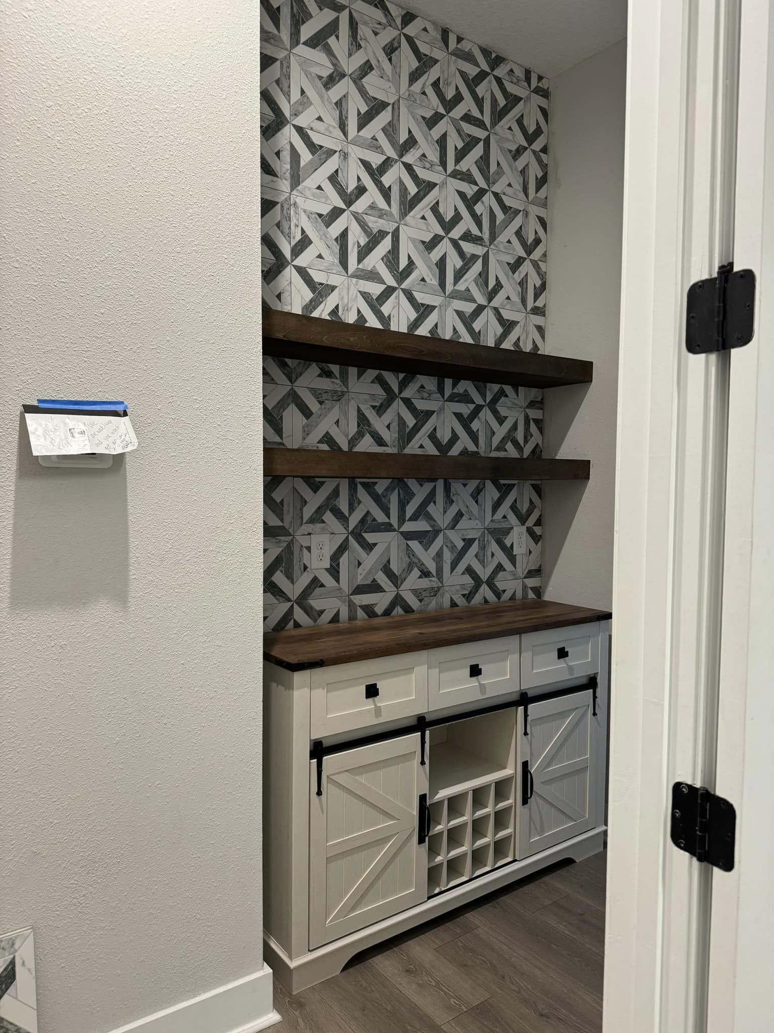 Custom built-in wet bar with tile backsplash and floating shelves
